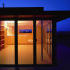 Living area lit at night with the kitchen and dining area beyond