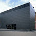 The administration building sports a black ceramic rainscreen, which contrasts with the red brick of the original structure