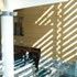 The louvres on the front facade pattern the walls of the central hall with light