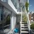 A robust stair leads from the lower terrace to the upper floor, with a spiral stair going up to the roof