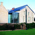 Crisp detailing of the glazed foyer link, the stone facades and the roofs contrasts with the vernacular form