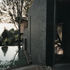 A ramp is glimpsed through the front door with kitchen window-door onto pool, where water spills over far lip and is then recycled