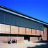 The new structure extends over the partly demolished south elevation to provide a framework from which an enclosing curtain of glass and cedar is hung