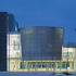 The curved wall of the auditorium marks the entrance to the business school, left, and Queen