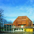 Main entrance, building depicting a barn-type morphology cladded in laminated timber larch boarding 