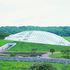 The single span glass roof caps the top of the hill