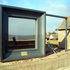 The reflected glass creates a constantly changing framed beach scene