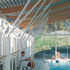 The supporting steel frames hold the curved timber roof structure