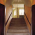 View up towards the landing from the entrance vestibule, which is vaulted with board-marked concrete
