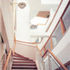 View up staircase showing combination of wood, glass and white render