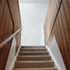Top floor stairs with outline of the original hayloft stair balustrade/stringer (painted white) surrounded by softwood timber boarding. (Phase II - masionette)