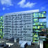 A grey perforated screen shields offices on the city-facing elevation