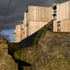 The larch cladding juxtaposes the stone wall of the school