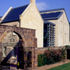 Crisp detailing of the glazed foyer link, the stone facades and the roofs contrasts with the vernacular form
