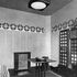 The study with black furniture, vivid yellow radiator screen, primrose yellow walls and orange, red, blue, grey and yellow stencilling