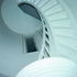 Cantilevered stone treads give way to spiraling joinery at the top of the staircase tower