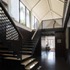 Perforated balustrades surround the opening and form edges to the open treaded steel stair