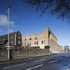 A large pharmacy with a timber and glazed frontage addresses the entrance to the site’s car park