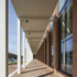 An insulated aluminium standing-seam roof system is supported on 24m-long Siberian Larch glulam beams at 3m centres to correspond with the brick piers and colonnade columns