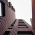 Wrapping the CLT superstructure is a protective lattice made of double-stacked brick with an open stretcher bond