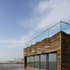 A glass-walled, open-air room enjoys views of town and coast and beyond, over the sea towards Europe