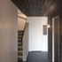 The ‘home-made’ acoustic ceiling in the ground-floor corridor consists of thin strips of black painted timber suspended below a shallow void