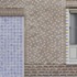 The brickwork features thicker alternating projecting courses at lower level, giving gentle rustication and weight to the base