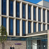 The façade comprises a high-quality brickwork base with a series of modest, punctuated windows at ground-floor level and then two storeys of deep precast concrete piers and sills set on a 1.5m grid