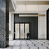 A trabeated structure of black terrazzo marks the entrance portico