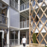 A checkerboard of white panels and glass windows is enclosed by a timber lattice structure