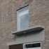 The bay and the porch detailing is made special by a rich-brown porcelain tile and red clay brick