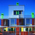 Rear elevation of the three-storey housing- the facades combine a lightweight industrial aesthetic with the warmth of natural materials, and a chirpy use of colour.jpg