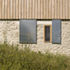 The rubble stone walls are typical of this part of France as are timber shuttered windows and sliding galvanised steel doors on local farm buildings