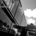 In bright sunlight, the minimal glass form reflects light like a mirror, seemingly disappearing, leaving only the surrounding elements – visions of the sky, brickwork, and trees.