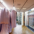 Dresses are carried on glowing glass fins, sliding across the ceiling.