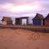 The hut stands out next to the more traditional beach huts