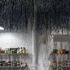The broom handles rise through the shelves to meet the hanging raffia 