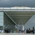 Passengers mull under the canopy at the entrance to the airport