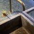 Architect conceived and cast concrete sink with separate drainage area to garden elevation.  Food preparation areas are denoted by suitably appropriate materials.  Modularity and smaller-sized elements allow greater negotiation and cost savings.