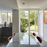 Kitchen: Diffuse light and garden foliage reflects in self-finished interiors, through large patio doors
