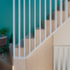 The bold green wall links loft and first floors, while an under-stair cupboard is captured between balustrades