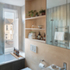 A plywood wall neatly houses various bathroom elements, while shutters avoid the need for frosted glass to the street-facing window