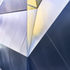 Close-up view of the folded  semi-reflective surface and vertical coated glass fin showing gold reflected light