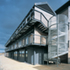 View of external walkway and spiral staircase which are formed of galvanised steel, with perforated lightweight metal decks