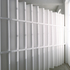 Photograph of exhibition during install, view of paper wall. 