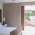 Bedroom with screen part-pulled back. Note random rhythm in balustrade and in custom-made bed