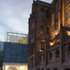 Both the original building and the extension are designed in three parts, with the extension’s glazed ground storey, bronze-clad middle storey and glass-encased roof responding to the original’s base, set-back upper two storeys and pitched roof