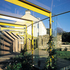 The pergola follows the curve of the driveway wall and rests lightly on its top