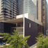 On 54th Street toward gallery block. Note reglazing to base of Pelli tower, which indoors changes to matt stone slabs