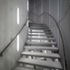 The treads of the new staircase hang from the inner concrete shell